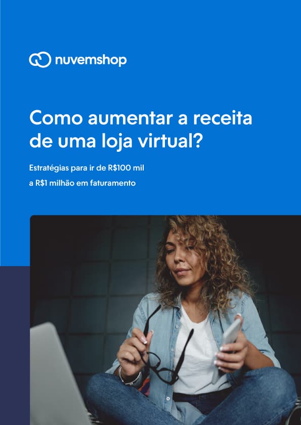 mulher sentada com as pernas juntas olhando para o notebook enquanto segura um telefone e os óculos de grau nas mãos